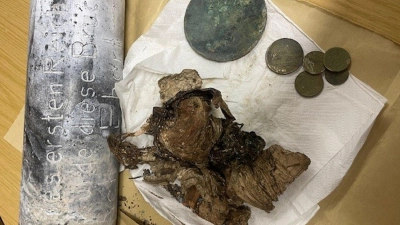 Silber- und Kupfermünzen, ein Zeitungsartikel und Fotos wurden seit dem beim Bau einer Brücke in Hof im Jahr 1928 in einer Zeitkapsel aufbewahrt. Nun sind die Gegenstände beim Abriss des Bauwerks wiedergefunden worden. (Foto: -/Stadt Hof/dpa)