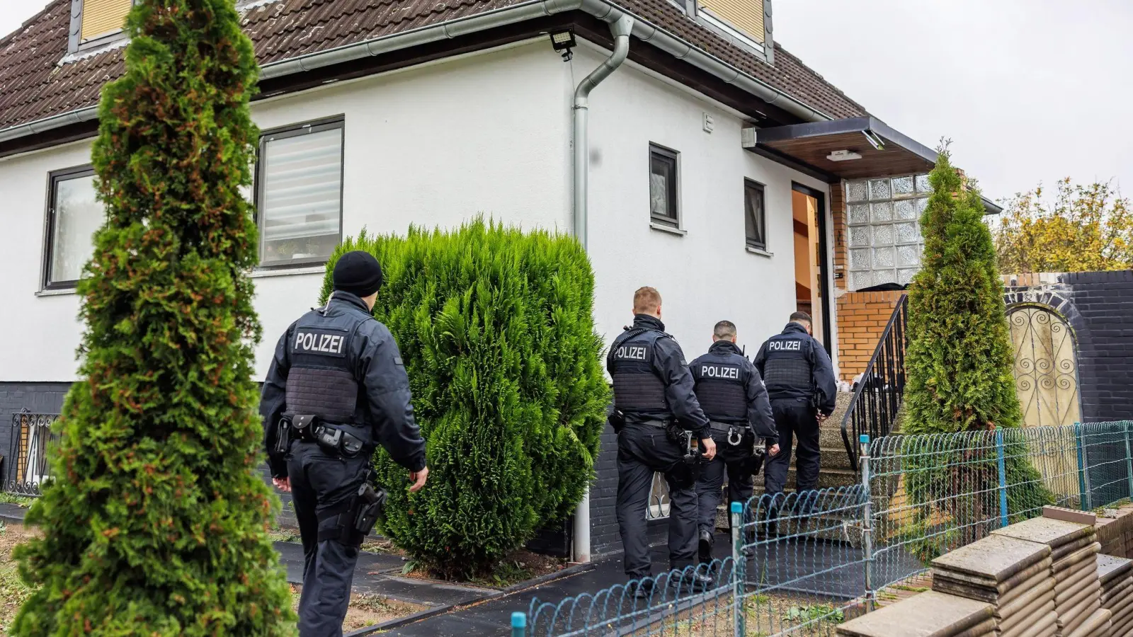 Polizeibeamte durchsuchen ein Haus in einer Wohnsiedlung in Garbsen. (Foto: Ole Spata/dpa)