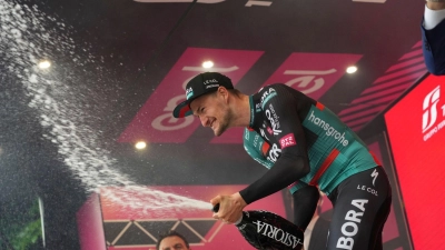 Der deutsche Radprofi Nico Denz vom Team Bora-hansgrohe feiert auf dem Podium seinen Etappensieg. (Foto: Gian Mattia D'Alberto/LaPresse/AP/dpa)