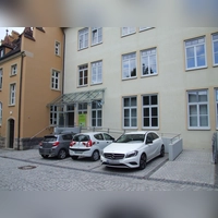 Das Erdgeschoss des Rathauses II ist über einen barrierefreien Aufgang zu erreichen, die anderen Stockwerke bislang nur über Treppen. Geplant ist die Errichtung eines Außenaufzugs. Diesem zum Opfer fallen würde der Parkplatz gleich an der Treppe.  (Foto: Jasmin Kiendl)