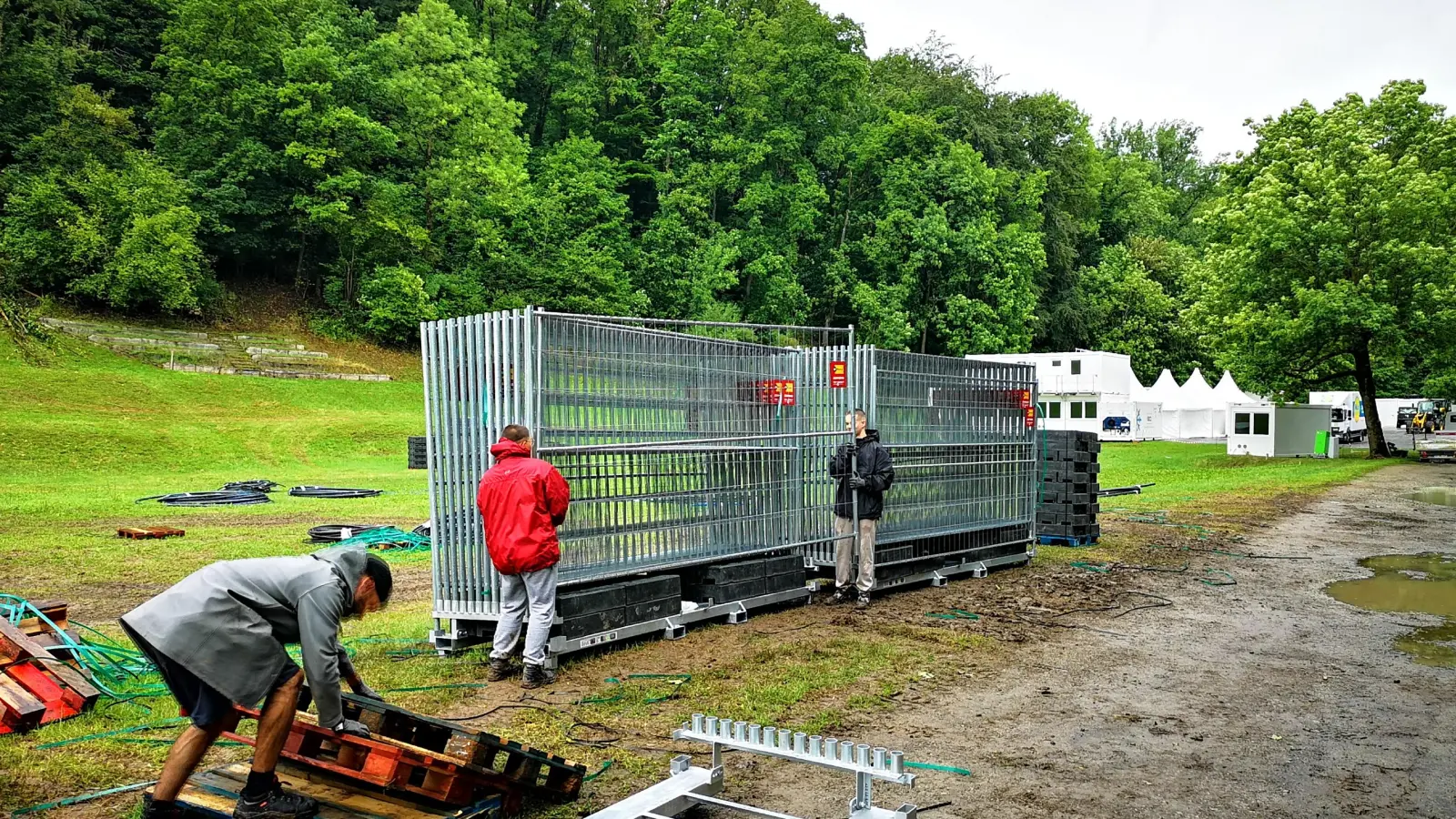 Der Aufbau der Festival-Infrastruktur läuft trotz des schlechten Wetters nach Plan. Zu denen, die vor Ort mitanpacken, gehören Jonathan Ziegler, Eric Ketschik und Can Naser (von links). Insgesamt sind rund 50 Personen im Einsatz, darunter neben Stammkräften auch Ferienjobber. (Foto: Jürgen Binder)
