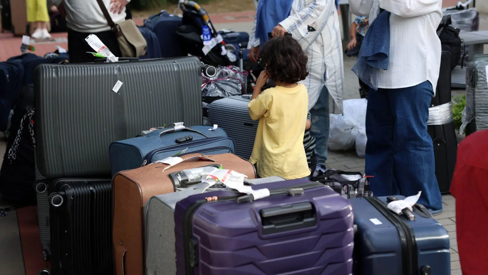 Menschen aus Afghanistan, die zuvor mit einem Flugzeug am Flughafen Hannover gelandet sind, stehen im Grenzdurchgangslager Friedland an ihren Koffern.  (Foto: Stefan Rampfel/dpa)