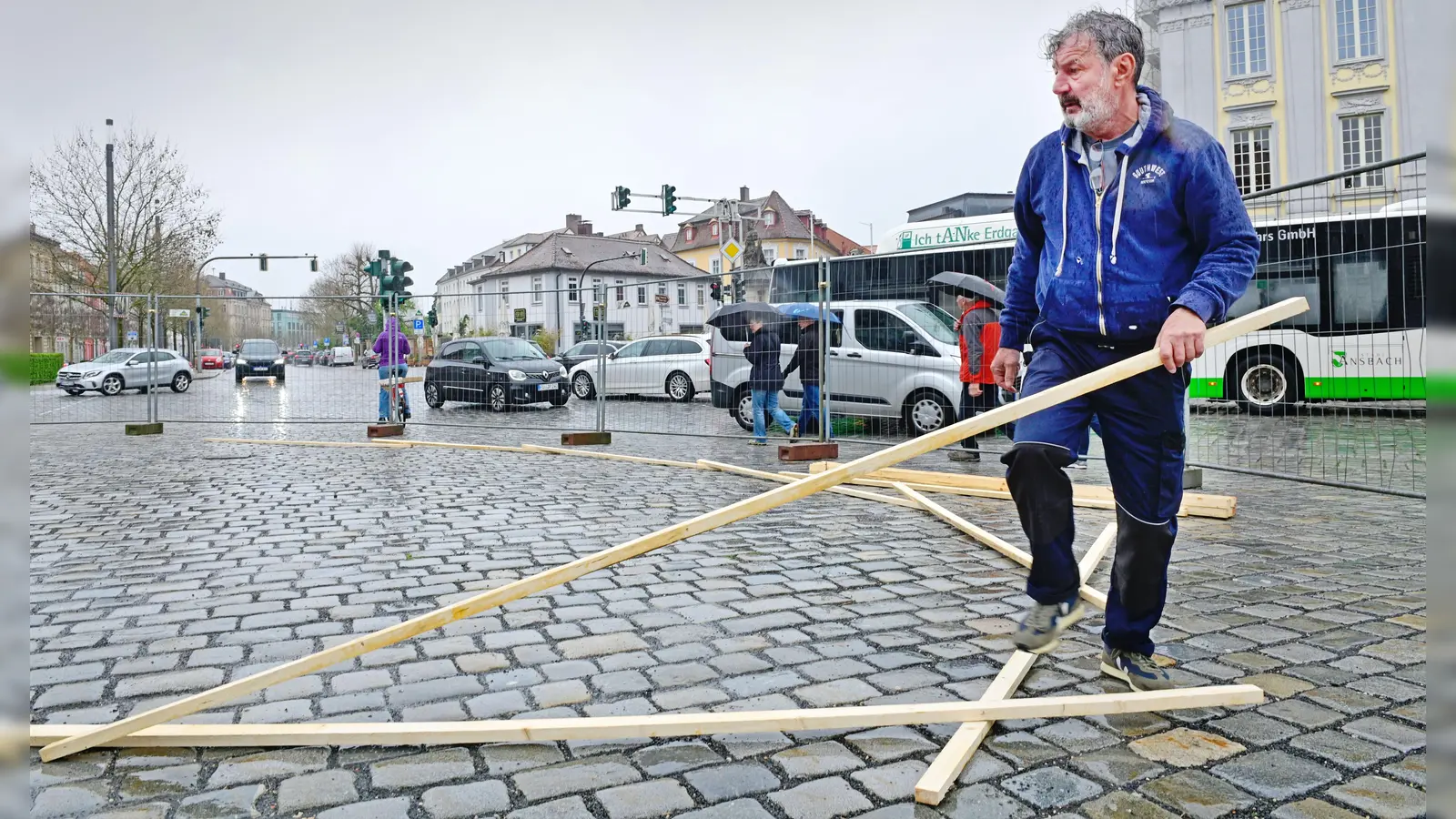 28. April 2023: Martin Steinerts beginnt bei Regen mit seiner Holzskulptur „Alles im Fluss” auf dem Ansbacher Schlossplatz. (Foto: Jim Albright)