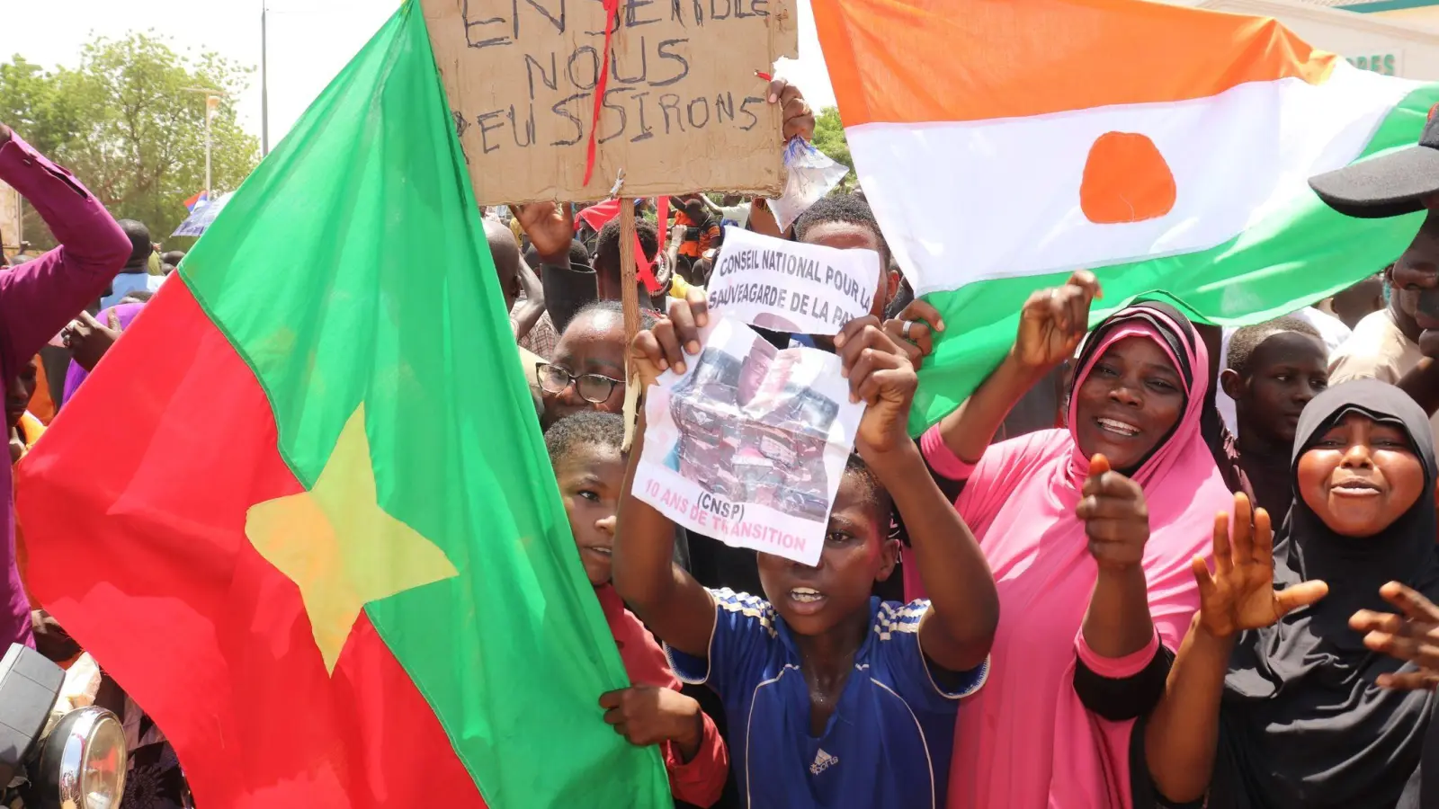Befürworter des Putschs halten eine Flagge von Burkina Faso (l) und Niger hoch. Die beiden Länder haben einen Pakt geschlossen. (Foto: Djibo Issifou/dpa)