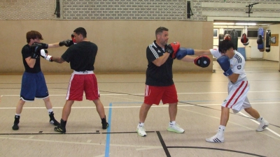 Der Vorsitzende und Cheftrainer des Boxclubs Feuchtwangen, Donato Braico (2. von rechts), bereitet seine Aktiven Omid Rezaie (rechts) sowie (von links) Zakiuallah Sadat und Mihai Irinel Lulea derzeit auf den Vergleichskampf im Mooswiesen-Weinzelt vor. (Foto: Jasmin Kiendl)