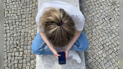 Typische Haltung in heutiger Zeit: mit gesenktem Kopf auf das Handy schauen. (Foto: Ricarda Dieckmann/dpa-tmn)