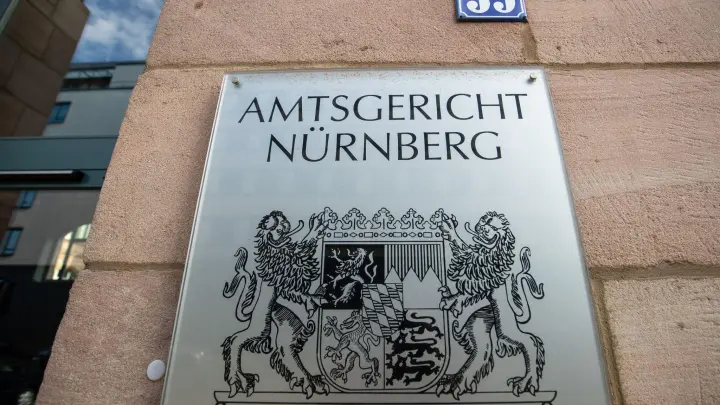 Ein Schild mit dem bayerischen Wappen und dem Schriftzug „Amtsgericht Nürnberg“. (Foto: Daniel Karmann/dpa)