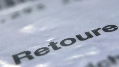 Das Wort „Retoure“ steht auf dem Retourenaufkleber eines in Folie verpackten Päckchens, welches an einen Online-Versandhändler zurück geschickt werden soll. (Foto: Karl-Josef Hildenbrand/dpa)