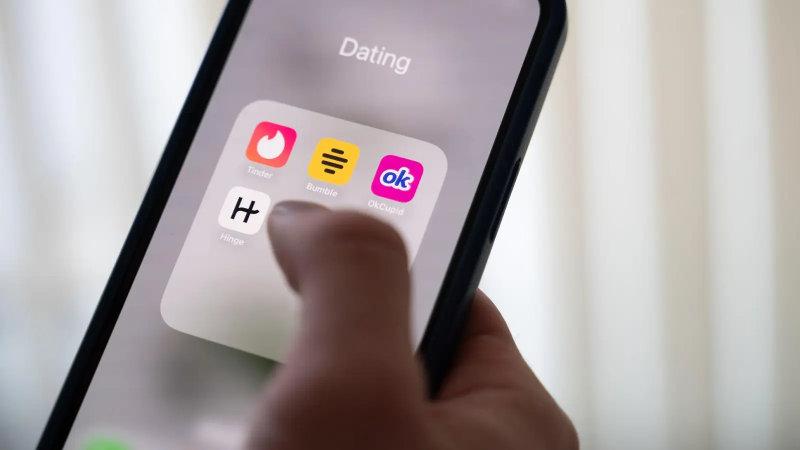 Eine Frau hält ein Smartphone, auf dem Dating-Apps angezeigt werden. (Symbolbild) (Foto: Alicia Windzio/dpa)