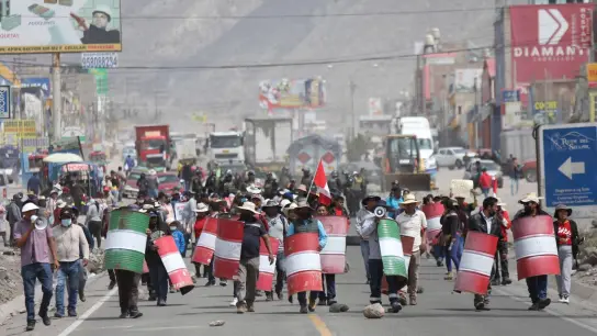 Demonstranten marschieren bei einem Protest gegen die Regierung von Präsidentin Boluarte mit behelfsmäßigen Schildern über eine Straße im peruanischen Arequipa. (Foto: Fredy Salcedo/AP/dpa)