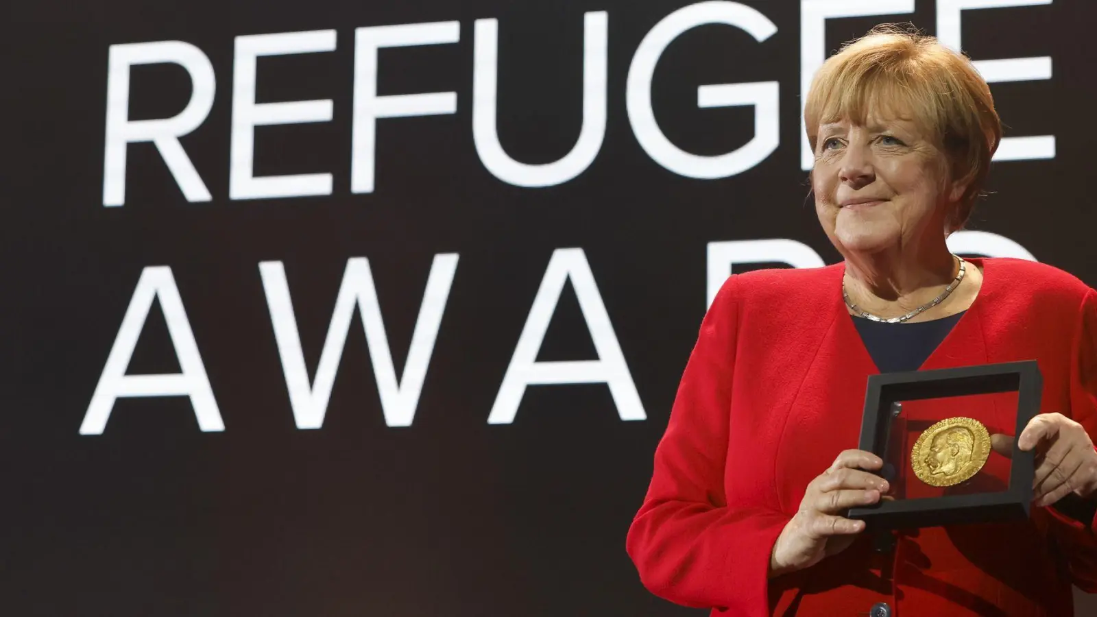 Merkel bei einer Preisverleihung für ihre Flüchtlingspolitik (Foto: Stefan Wermuth/KEYSTONE REUTERS POOL/dpa)