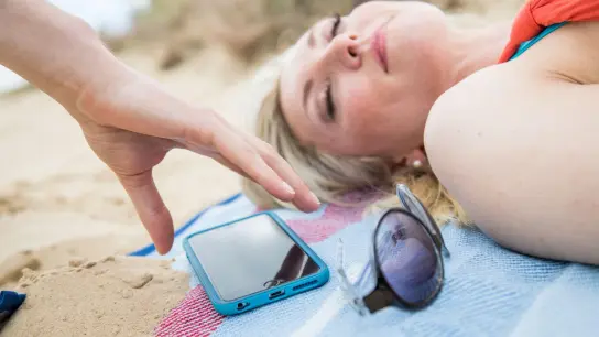 Nur mal kurz nicht aufgepasst, und schon ist es passiert: Damit das Handy am Strand nicht geklaut wird, sollte man es besser nicht unbeaufsichtigt lassen. (Foto: Christin Klose/dpa-tmn)