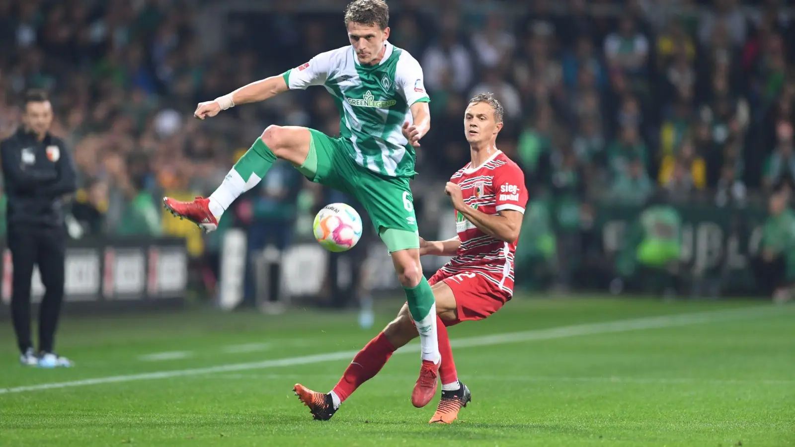 Werders Jens Stage (l) kämpft gegen Augsburgs Robert Gumny um den Ball. (Foto: Carmen Jaspersen/dpa)