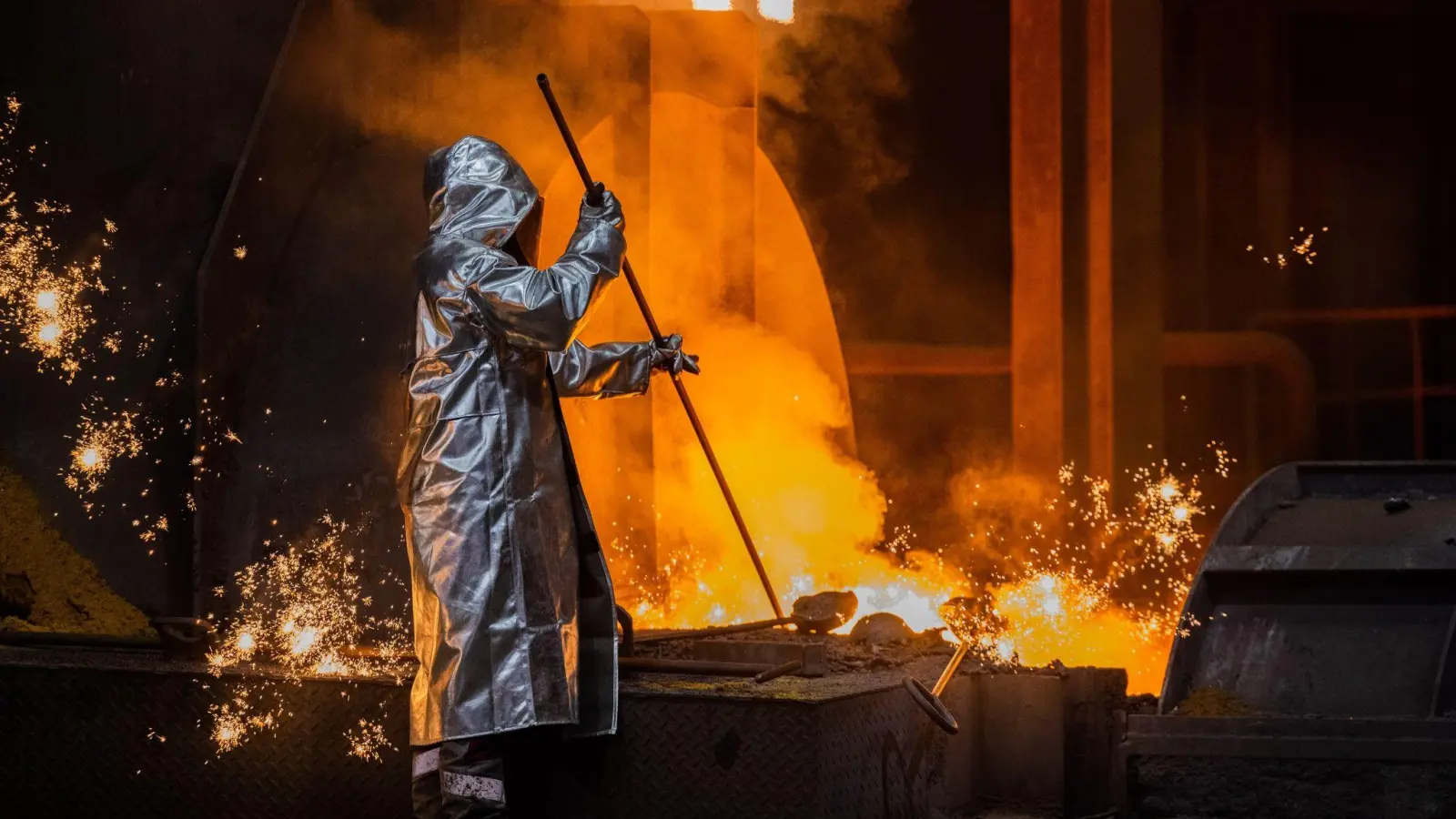 Ein Stahlarbeiter von Thyssenkrupp prüft Roheisen am Hochofen 8 auf dem Werksgelände. (Foto: Rolf Vennenbernd/dpa)