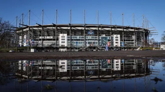 Hauptversammlung der Fußball AG des Hamburger SV. Das Volksparkstadion spiegelt sich in einer Pfütze auf dem Parkplatz vor dem Stadion. (Foto: Christian Charisius/dpa)