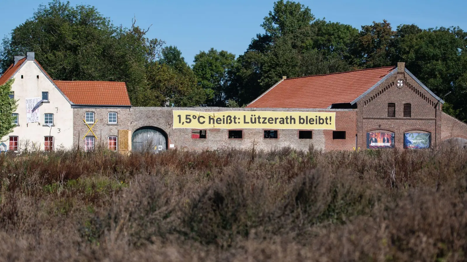 Ein Banner mit der Aufschrift „1,5 Grad heißt: Lützerath bleibt!“ an einem alten Hof in Lützerath. Doch nun soll das Dorf weichen. (Foto: Marius Becker/dpa)