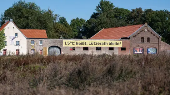 Ein Banner mit der Aufschrift „1,5 Grad heißt: Lützerath bleibt!“ an einem alten Hof in Lützerath. Doch nun soll das Dorf weichen. (Foto: Marius Becker/dpa)
