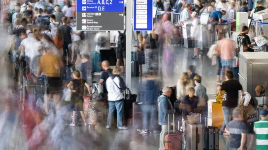 Tausende Passagiere warten vor den Abfertigungsschaltern des Flughafens auf ihren Check-In. (Foto: Boris Roessler/dpa)