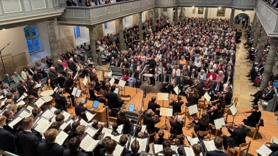 Blick in die Notenblätter: Der Windsbacher Knabenchor und das Freiburger Barockorchester singen und musizieren in der voll besetzten Gumbertuskirche ...  (Foto: Lara Hausleitner)