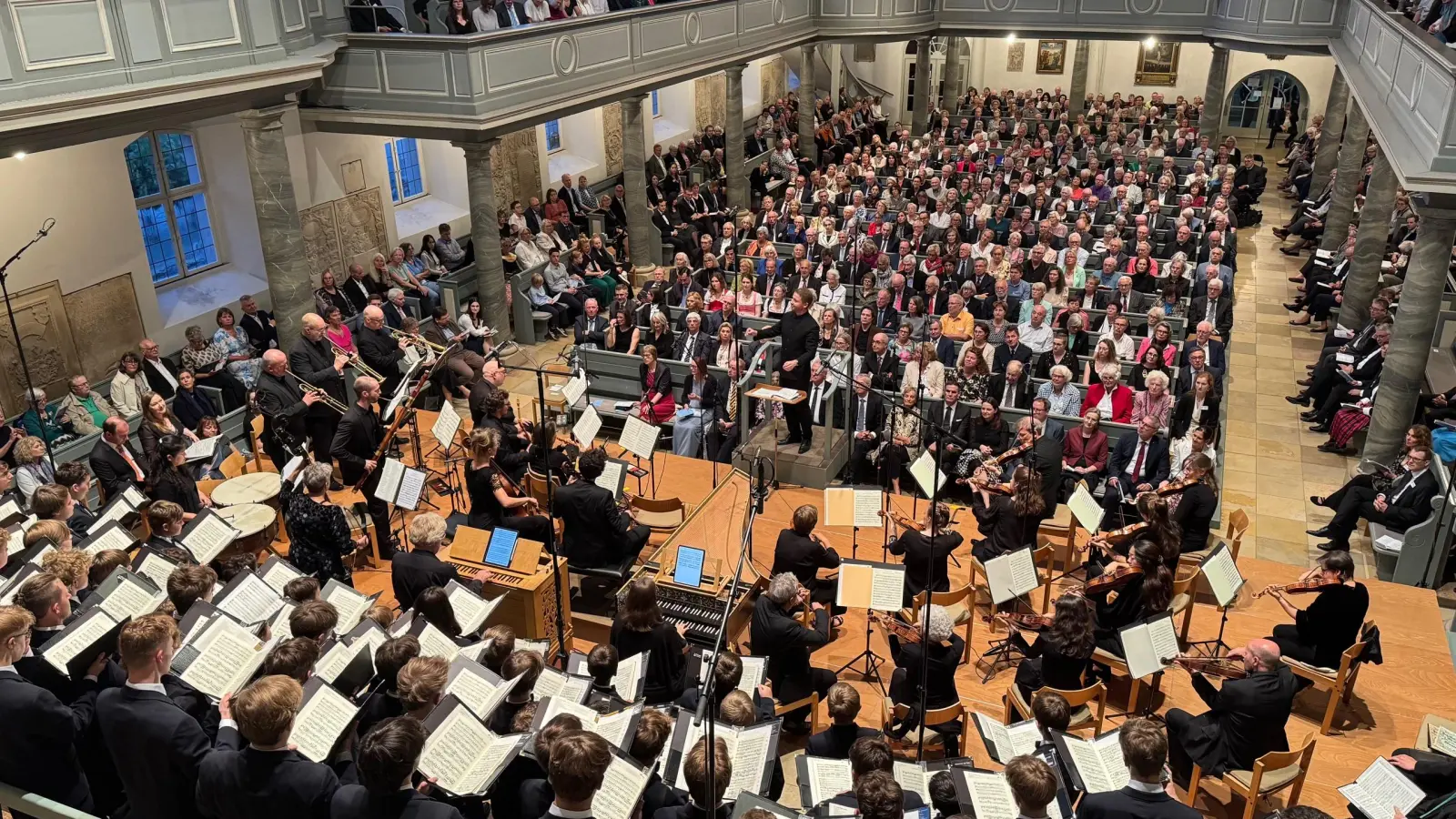 Blick in die Notenblätter: Der Windsbacher Knabenchor und das Freiburger Barockorchester singen und musizieren in der voll besetzten Gumbertuskirche ...  (Foto: Lara Hausleitner)