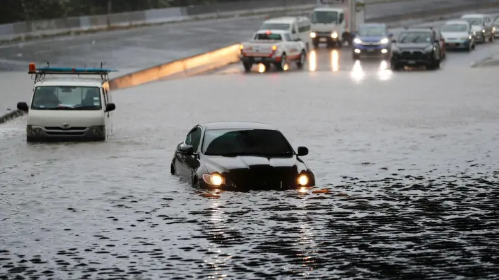Fahrzeuge im Hochwasser auf einer überschwemmten Straße in Auckland. (Foto: Dean Purcell/New Zealand Herald/dpa)