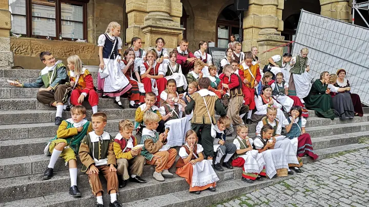 Die Reichsstadttage in Rothenburg sind auch ein Fest der Kinder. Das Foto zeigt junge Aktive auf der Treppe vor dem Rathaus. Einige haben sich ein Eis besorgt. (Foto: Jürgen Binder)