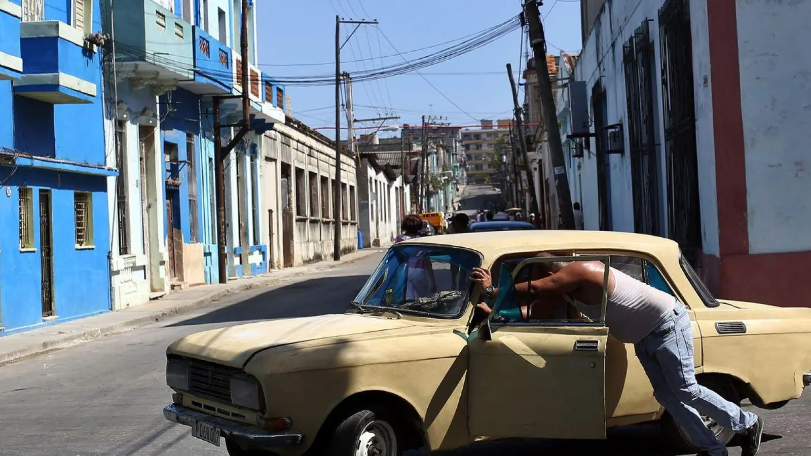 Ein Mann schiebt sein kaputtes Auto durch eine Straße in der kubanischen Hauptstadt. (Foto: Ernesto Salazar/ZUMA Wire/dpa)