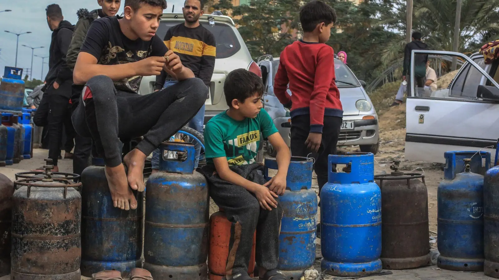 Palästinensische Kinder in Chan Junis stehen Schlange, um Flüssiggasflaschen aufzufüllen. (Foto: Mohammed Talatene/dpa)