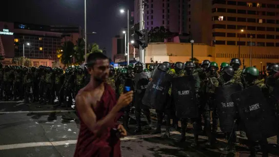 Ein buddhistischer Mönch filmt, wie Soldaten die Demonstranten vom Gelände eines Protestcamps in Colombo entfernen. (Foto: Rafiq Maqbool/AP/dpa)