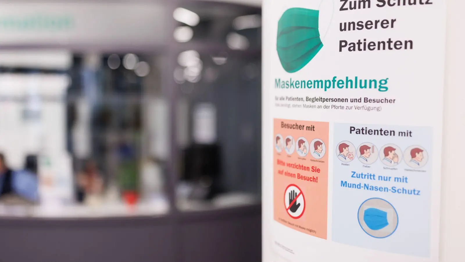 Am Eingangsbereich am Uniklinikum Erlangen weist ein Plakat auf eine „Maskenempfehlung” für alle hin. (Foto: Daniel Karmann/dpa)
