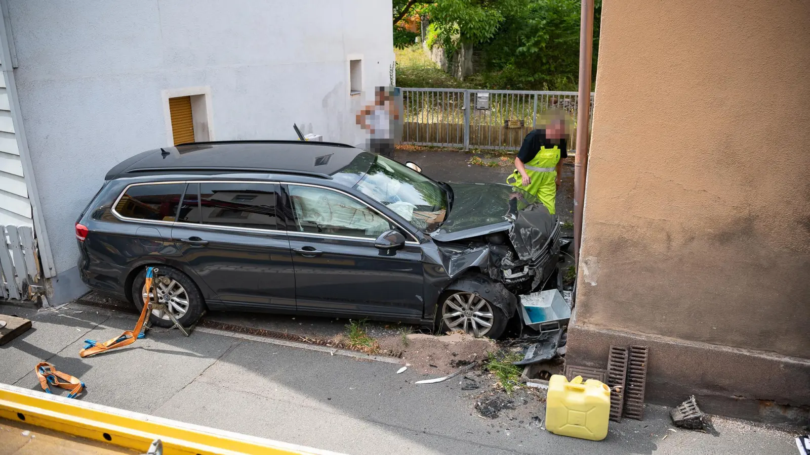 Fast wie eingeparkt wirkt dieser Unfallwagen am Samstag in Emskirchen. Die Fahrerin war mit dem Kombi über die Gegenfahrbahn in diese Lücke zwischen zwei Wohnhäusern gerutscht. (Foto: Mirko Fryska)