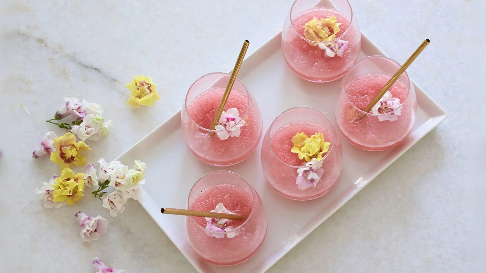 Der Tee-Frosé ist ein Mix von Cold Brew Tea und alkoholfreiem Roséwein und wird am besten mit essbaren Blüten dekoriert. (Foto: janrickers.com/Deutscher Tee & Kräutertee Verband e.V./dpa-tmn)