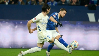Das 1:0 für Schalke: Adil Aouchiche schießt, Magdeburgs Jean Hugonet fälscht mit der Fußspitze ab - und der Ball fliegt im hohen Bogen ins Tor.  (Foto: Bernd Thissen/dpa)