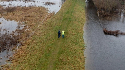 Mitarbeiter des Landesbetriebs für Hochwasserschutz in Wolmerstedt in Sachsen-Anhalt laufen einen Deich ab. (Foto: Stephan Schulz/dpa)