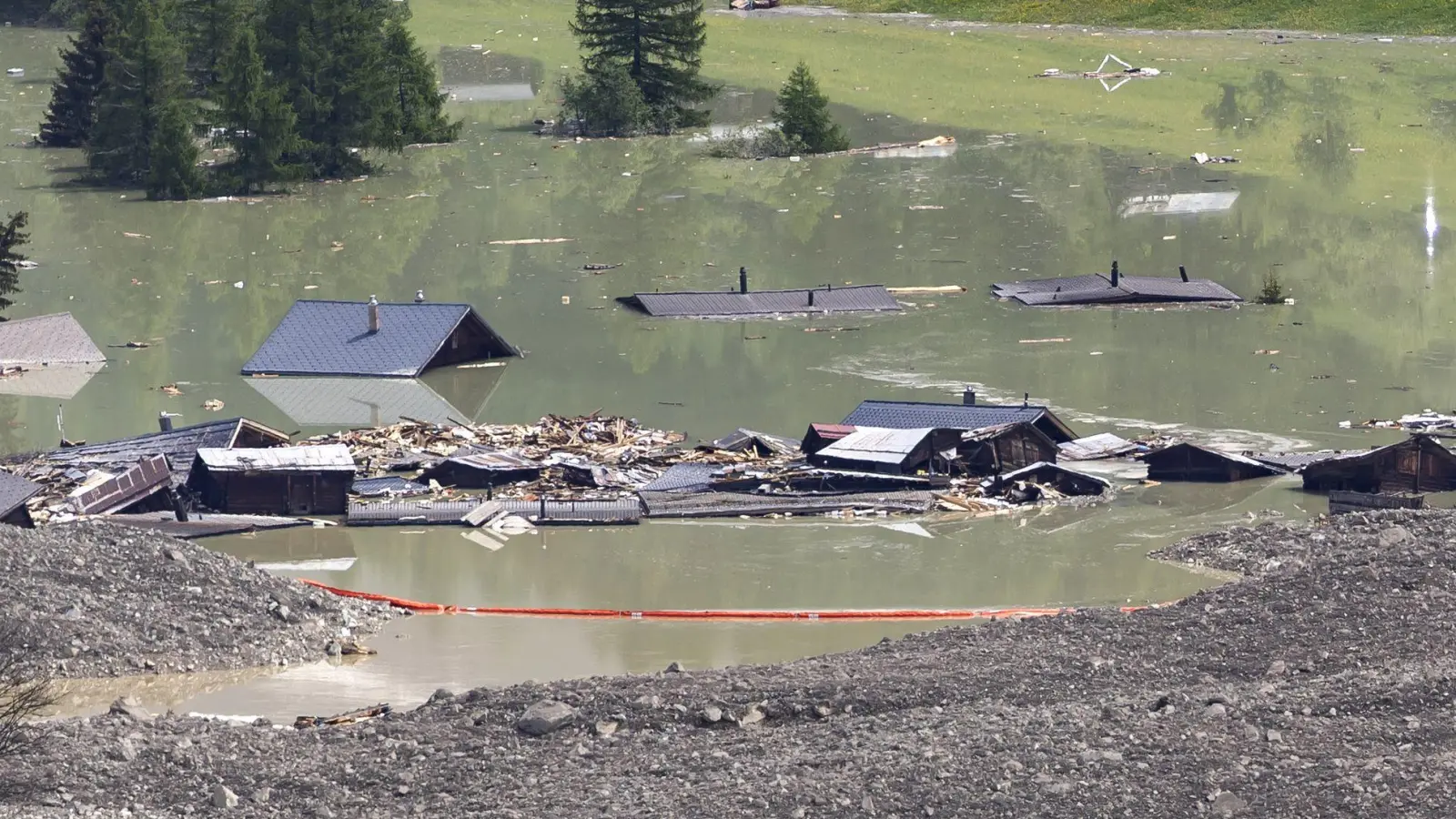 Rote Barrieren sollen Material zurückhalten, das den Abfluss der Lonza erneut verstopfen könnte.  (Foto: Cyril Zingaro/KEYSTONE/dpa)
