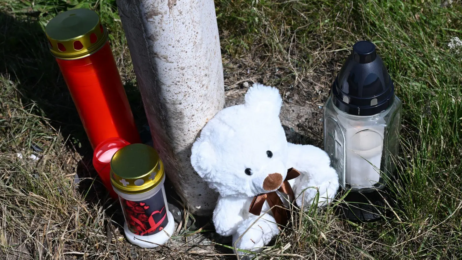 Menschen haben Kerzen und einen Teddybären an der Unfallstelle abgestellt. (Foto: Bernd Weißbrod/dpa)
