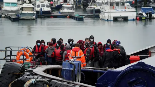 Flüchtlinge, die mit einem kleinen Boot im Ärmelkanal aufgegriffen worden war, wird im Hafen von Dover an Land gebracht. (Foto: Gareth Fuller/PA Wire/dpa)