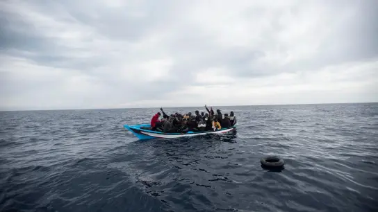 Ein Holzboot mit 28 Flüchtlingen aus Afrika und dem Maghreb wird von der Nichtregierungsorganisation Open Arms vor der libyschen Küste im Mittelmeer gerettet (Symbolbild). (Foto: Andoni Lubaki/AP/dpa)