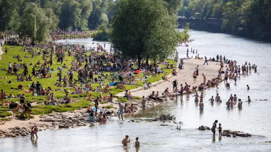 Zahlreiche Menschen baden bei sommerlichen Temperaturen in München in der Isar. (Foto: Matthias Balk/dpa)