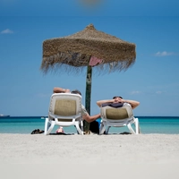 Entspannt am Strand: Wer sich vorher kurz mit möglichen Gesundheitsrisiken auseinandersetzt, ist im Urlaub relaxter. Sonnencreme nicht vergessen! (Foto: Julian Stratenschulte/dpa/dpa-tmn)