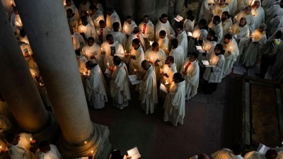 Katholische Geistliche halten Kerzen, während sie während der Prozession am Gründonnerstag zur Fußwaschung in der Grabeskirche in Jerusalem gehen. (Foto: Ohad Zwigenberg/AP/dpa)
