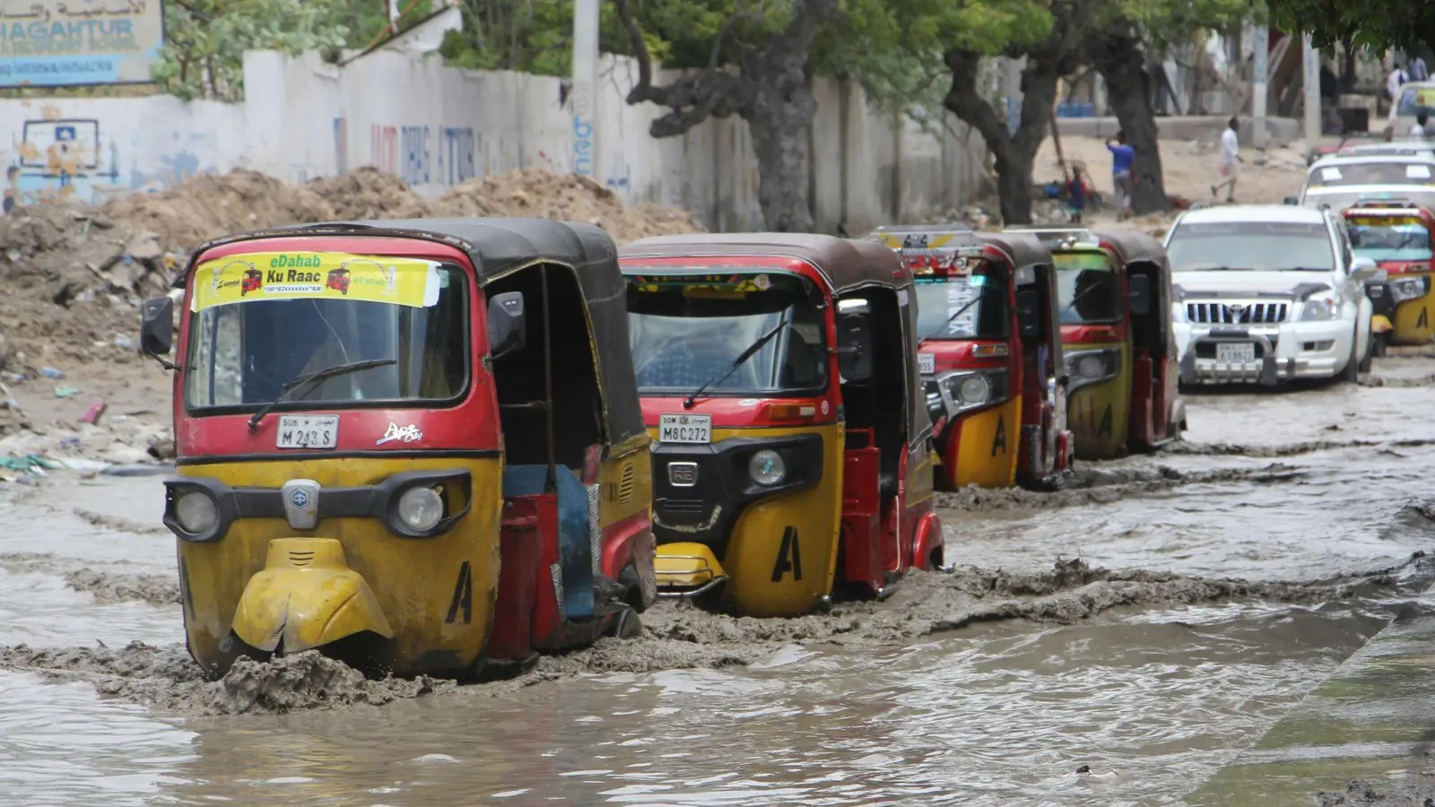 Tuktuks fahren durch eine überflutete Straße nach starkem Regen in Mogadischu. (Foto: Farah Abdi Warsameh/AP/dpa)
