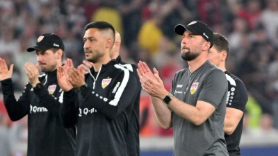 Stuttgarts Cheftrainer Sebastian Hoeneß (r) steht mit seinem Trainerteam nach dem Spiel auf dem Platz. (Foto: Jan-Philipp Strobel/dpa)