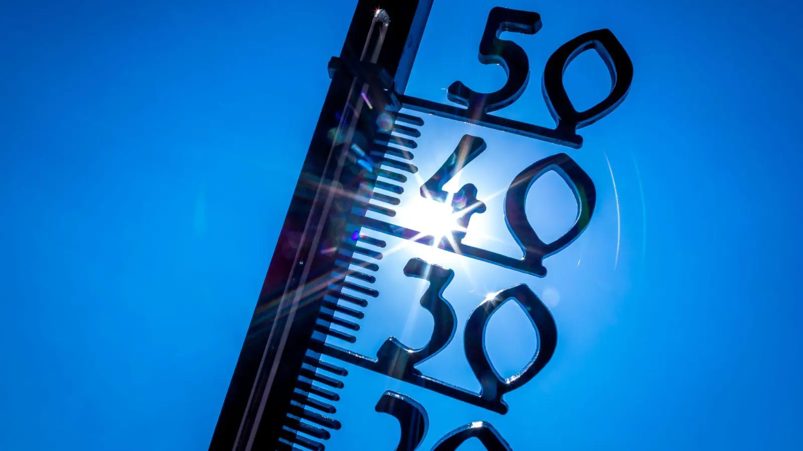 Ein Außenthermometer zeigt die Temperatur an: So heiß war es noch nie. (Foto: Jens Büttner/dpa)
