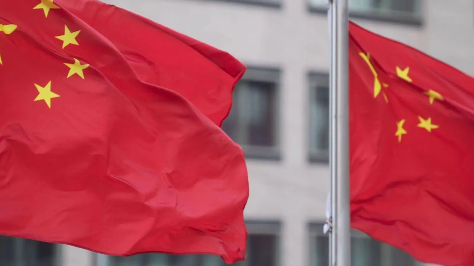 Flaggen der Volksrepublik China wehen an Fahnenmasten eines Hotels. (Foto: Marijan Murat/dpa/Archivbild)