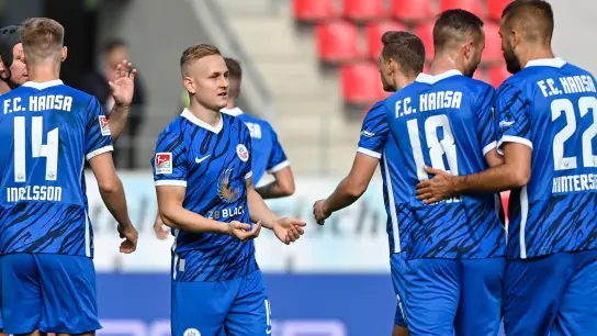 Die Mannschaft von Hansa Rostock jubelt nach dem Treffer zum 1:0 bei Jahn Regensburg. (Foto: Armin Weigel/dpa)