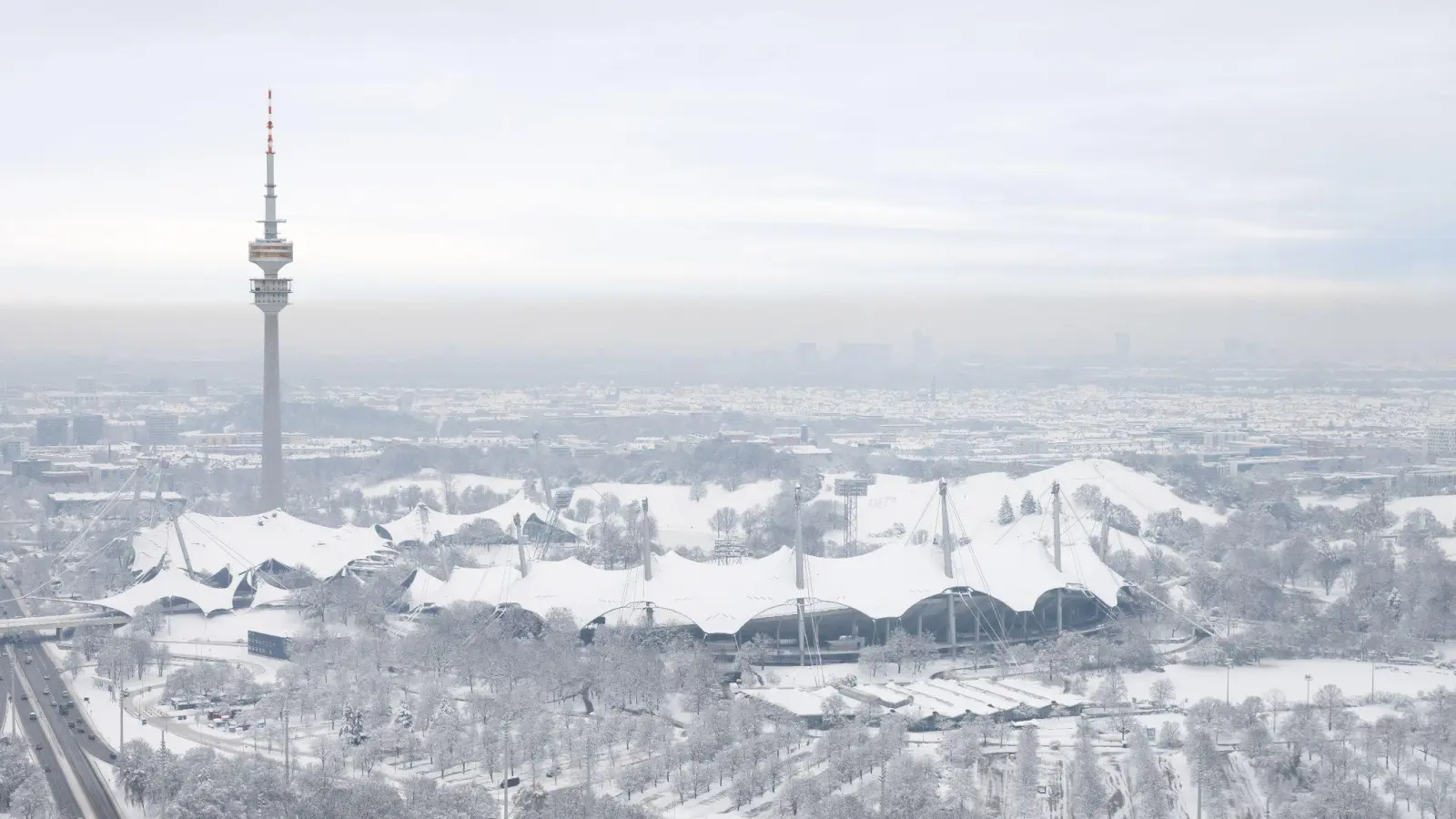 Der schneebedeckte Olympiapark mit dem Olympiaturm ist von einem Hochhaus zu sehen. (Foto: Sven Hoppe/dpa)
