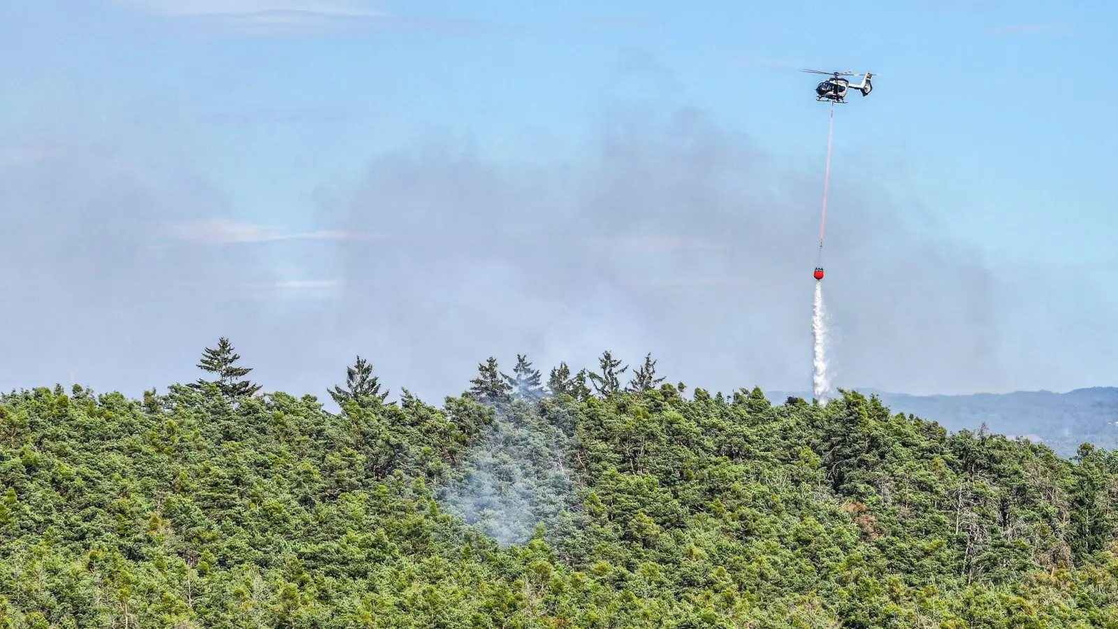 Mit einem Hubschrauber soll der Brand auch aus der Luft gelöscht werden.  (Foto: Jason Tschepljakow/dpa)