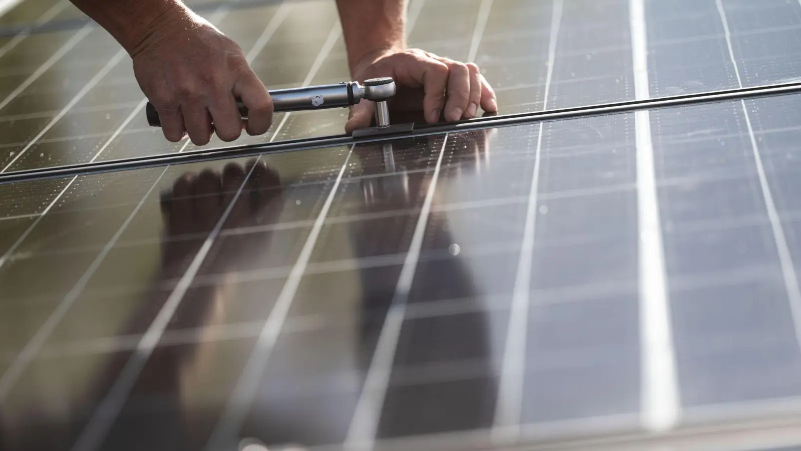 Mitarbeiter montieren Photovoltaikmodule auf dem Dach eines Wohnhauses. Die Nachfrage zu den Angeboten der Energieberatung ist stark gestiegen. (Foto: Marijan Murat/dpa)