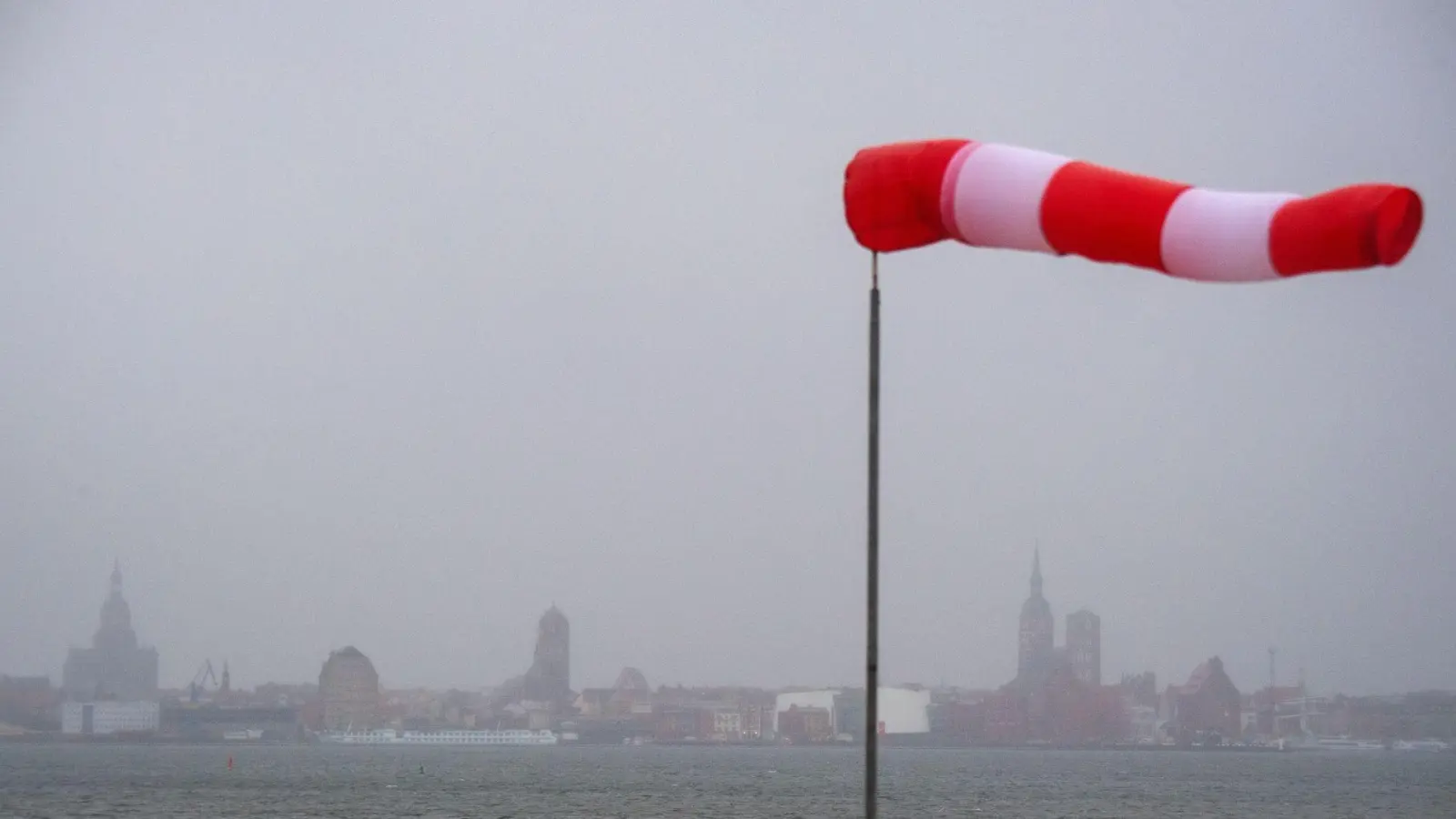 Ein Windsack steht fast horizontal in der Luft und zeigt den Wind an. (Foto: Stefan Sauer/dpa/ZB/Symbolbild)